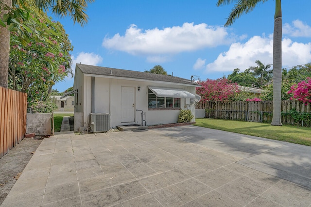 exterior space featuring a patio, a yard, and central air condition unit