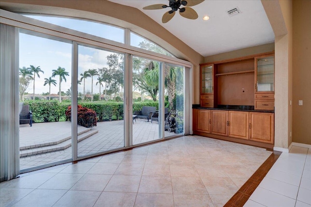 interior space featuring light tile patterned floors, ceiling fan, and lofted ceiling