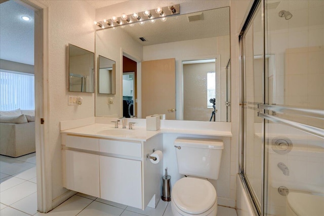 full bathroom featuring tile patterned floors, toilet, enclosed tub / shower combo, and a textured ceiling