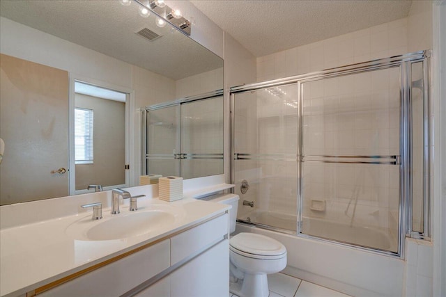 full bathroom with tile patterned floors, vanity, a textured ceiling, shower / bath combination with glass door, and toilet