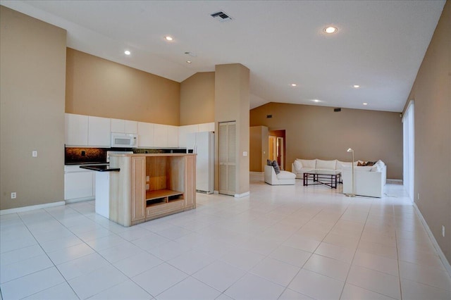 kitchen with white cabinets, white appliances, a center island, and light tile patterned flooring