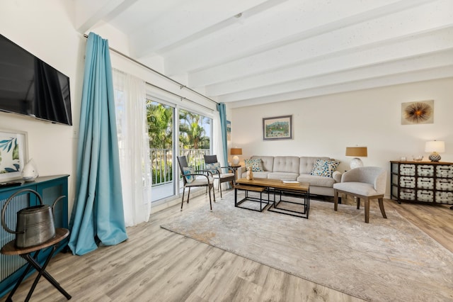 living room featuring beam ceiling and light hardwood / wood-style flooring