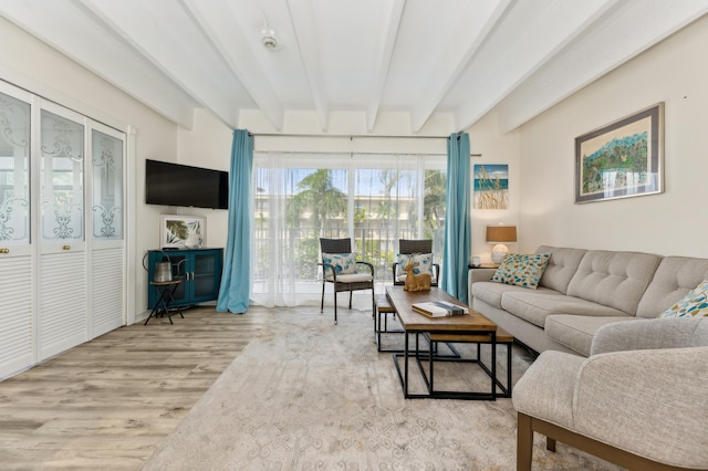 living room with light hardwood / wood-style floors and beamed ceiling