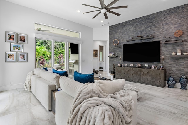 living room with a high ceiling and ceiling fan