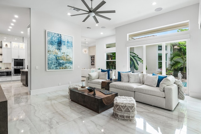 living room with ceiling fan with notable chandelier