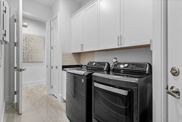 washroom with washer and clothes dryer and cabinets