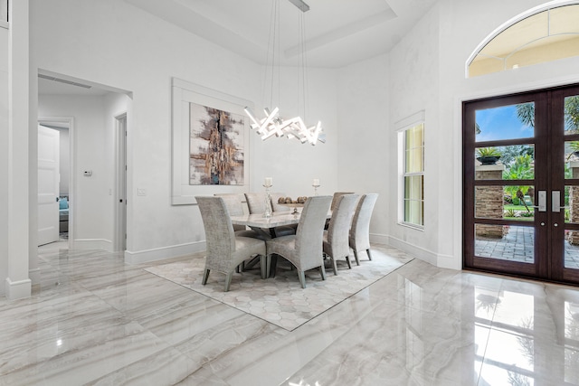 dining area featuring french doors and a towering ceiling