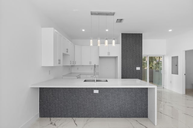 kitchen featuring white cabinetry, sink, kitchen peninsula, electric panel, and pendant lighting