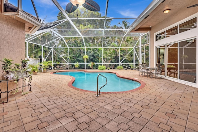 view of swimming pool with a patio and glass enclosure