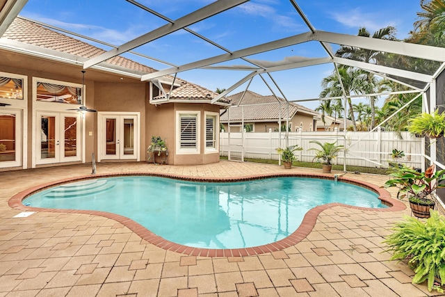 view of pool with french doors, a patio area, and glass enclosure