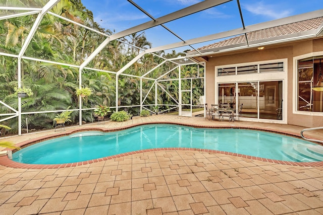 view of pool featuring a patio area and glass enclosure