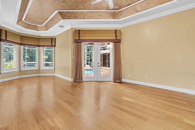 unfurnished room with ceiling fan, hardwood / wood-style flooring, ornamental molding, and a tray ceiling