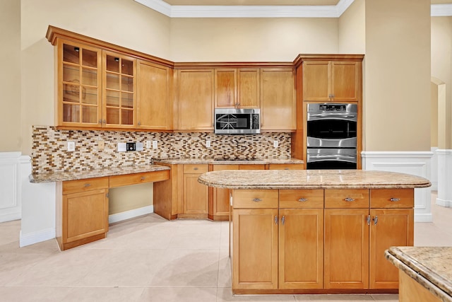 kitchen featuring light stone counters, stainless steel appliances, light tile patterned floors, and backsplash