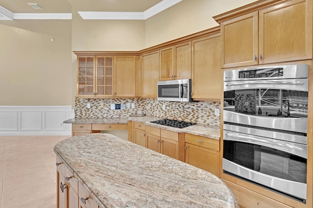 kitchen featuring light stone countertops, appliances with stainless steel finishes, ornamental molding, and decorative backsplash