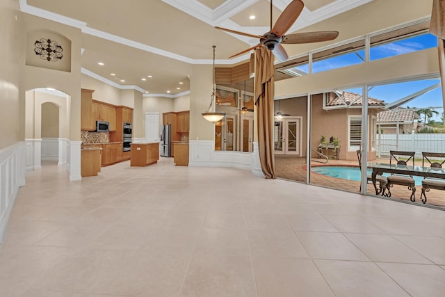 living room with ornamental molding, a high ceiling, and light tile patterned floors