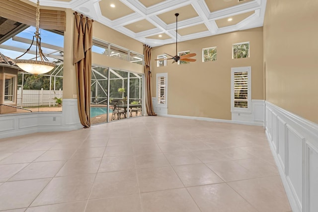 tiled empty room with ornamental molding, ceiling fan, and plenty of natural light