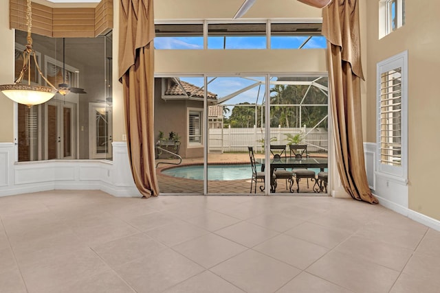 tiled empty room featuring a high ceiling