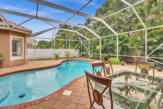 view of pool with a patio and glass enclosure