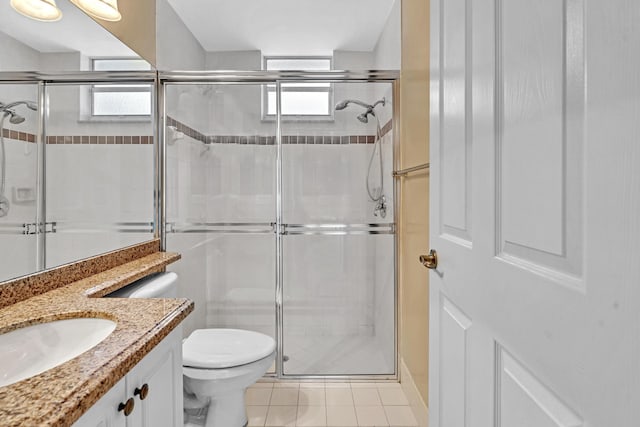 bathroom featuring vanity, toilet, tile patterned floors, and a shower with door