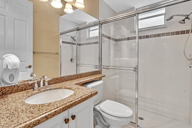 bathroom with vanity, a shower with shower door, and toilet