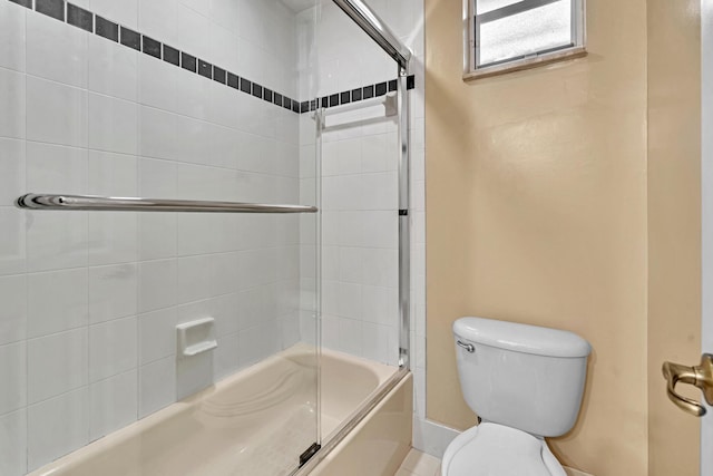 bathroom with toilet and bath / shower combo with glass door