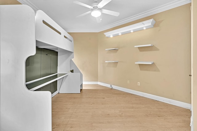 interior space with ceiling fan, ornamental molding, and light wood-type flooring