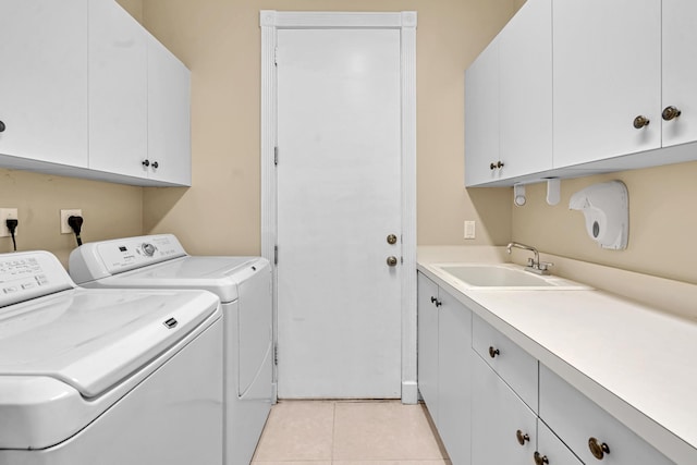 laundry room with sink, light tile patterned floors, cabinets, and washer and clothes dryer