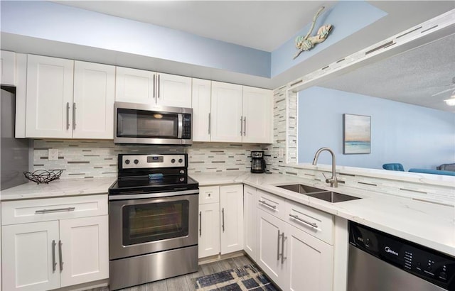 kitchen featuring sink, white cabinetry, decorative backsplash, and stainless steel appliances