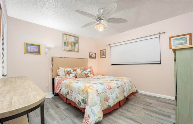 bedroom featuring hardwood / wood-style floors, a textured ceiling, and ceiling fan