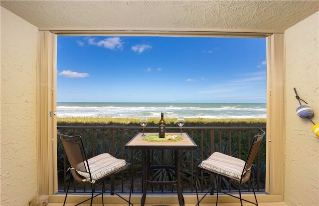 balcony with a water view and a beach view