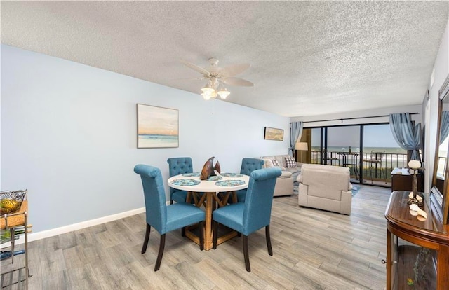 dining space featuring a textured ceiling, light wood-type flooring, and ceiling fan