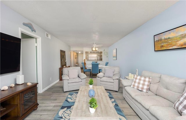 living room featuring light hardwood / wood-style flooring and ceiling fan