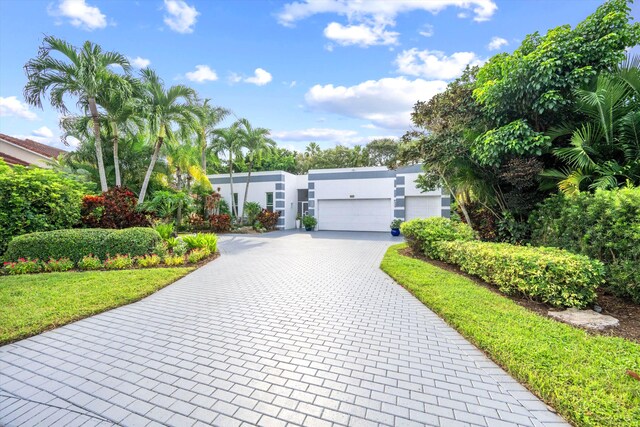 view of front of house with a front lawn, decorative driveway, and stucco siding