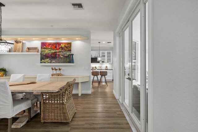 living area featuring a ceiling fan, a towering ceiling, visible vents, light wood-style floors, and french doors