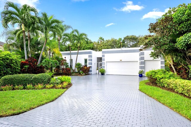 view of front of house featuring a garage, decorative driveway, and stucco siding