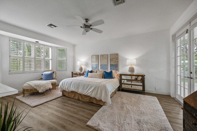 bedroom featuring access to exterior, visible vents, baseboards, and wood finished floors