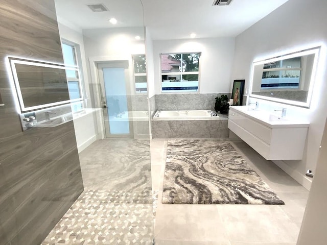 full bathroom featuring a healthy amount of sunlight, visible vents, a bath, and vanity