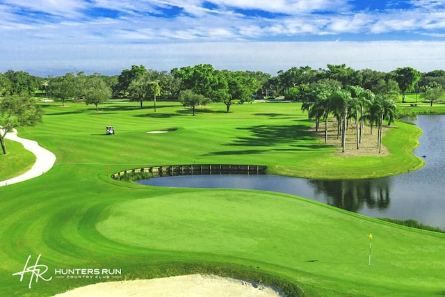 view of property's community with golf course view, a water view, and a lawn