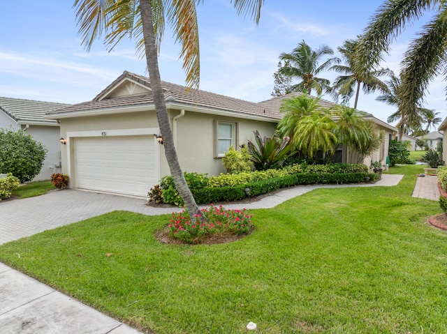 view of front of house with a tile roof, an attached garage, decorative driveway, a front lawn, and stucco siding