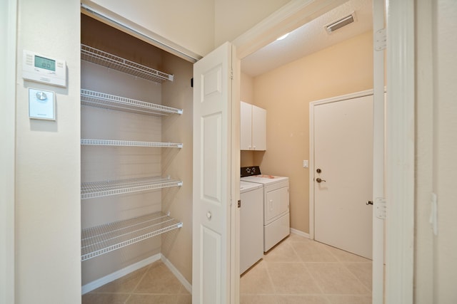 laundry room featuring light tile patterned flooring, washing machine and dryer, visible vents, baseboards, and cabinet space