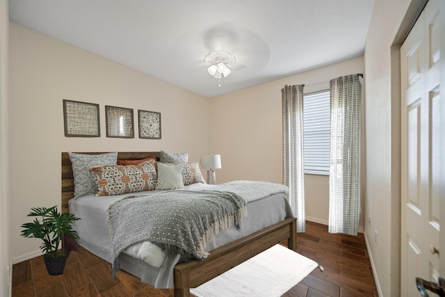 bedroom with dark wood-style flooring and baseboards