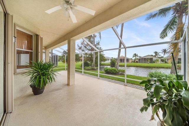 sunroom featuring a ceiling fan and a water view