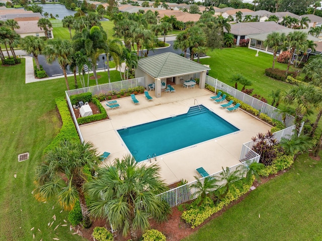 pool featuring a patio, a yard, and fence