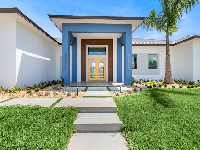 view of exterior entry featuring a lawn