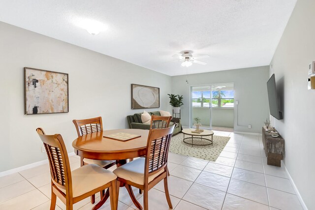 dining space featuring baseboards, ceiling fan, and light tile patterned floors