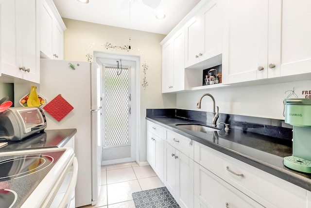 kitchen with dark countertops, open shelves, a sink, light tile patterned floors, and white cabinets
