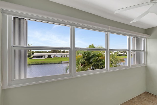 interior space with a water view and a ceiling fan