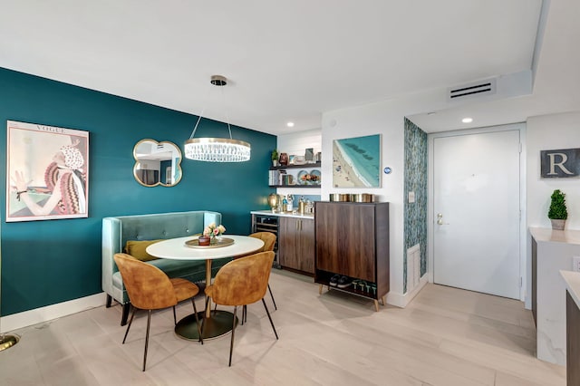 dining area featuring light hardwood / wood-style floors and an inviting chandelier