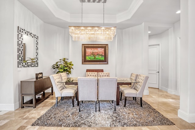 dining area with ornamental molding, a chandelier, and a tray ceiling