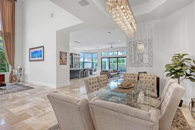 dining space with crown molding and ceiling fan with notable chandelier